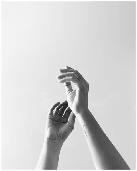 A graceful black and white close-up of reaching ha