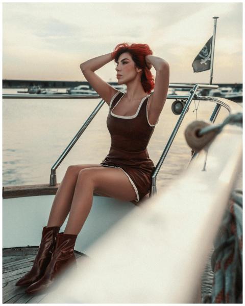 Elegant woman in a brown dress relaxing on a yacht