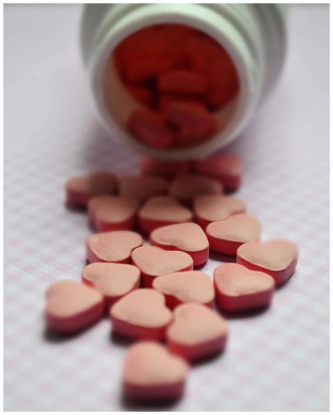 Close-up of heart-shaped pink pills spilled from a