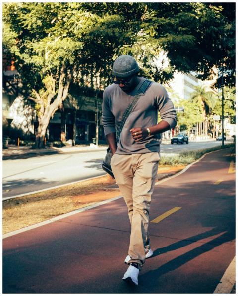 African American man walks down tree-lined street