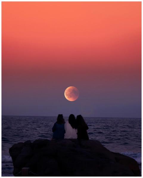 Three friends silhouetted against a vibrant twilig