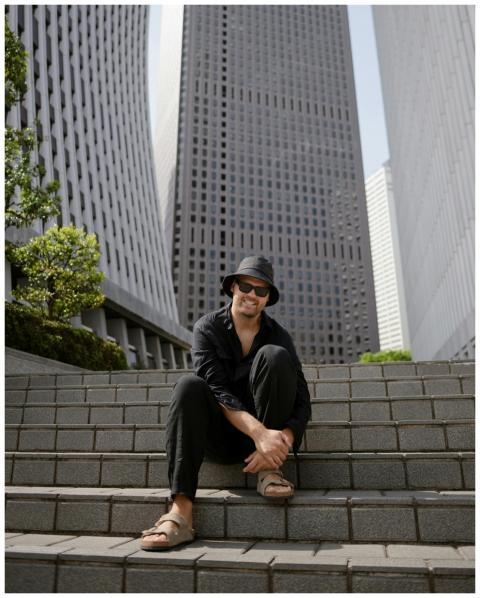 A person sits on steps surrounded by modern skyscr