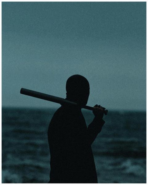 Moody silhouette of a man holding a baseball bat a