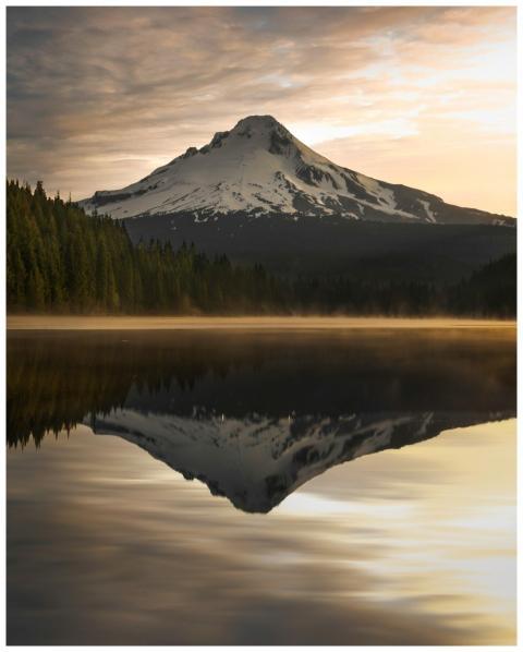 Idyllic sunrise view of snow-capped mountain refle