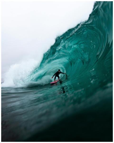 Surfer riding a massive wave, showcasing dynamic w