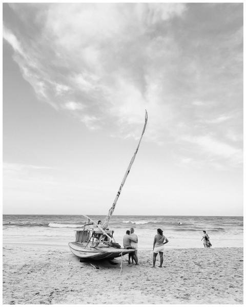 Serene beach scene with a fishing boat at Canoa Qu