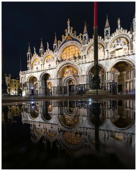 Illuminated St Mark's Basilica reflecting at night