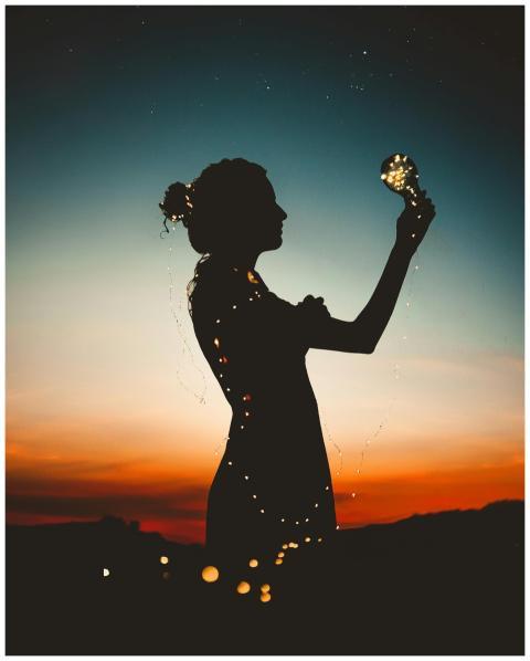 Artistic silhouette of a woman wrapped in fairy li