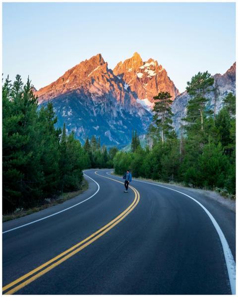 A cyclist on a winding road leads to the majestic