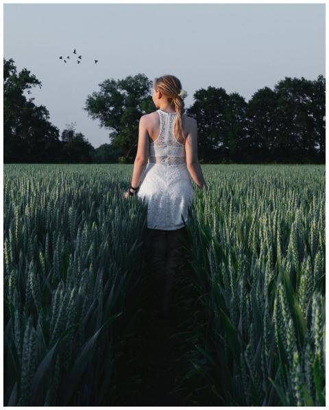 Blonde woman in white dress walking in a peaceful