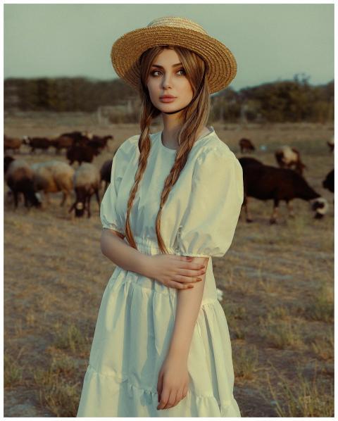 Elegant young woman in white dress and straw hat s