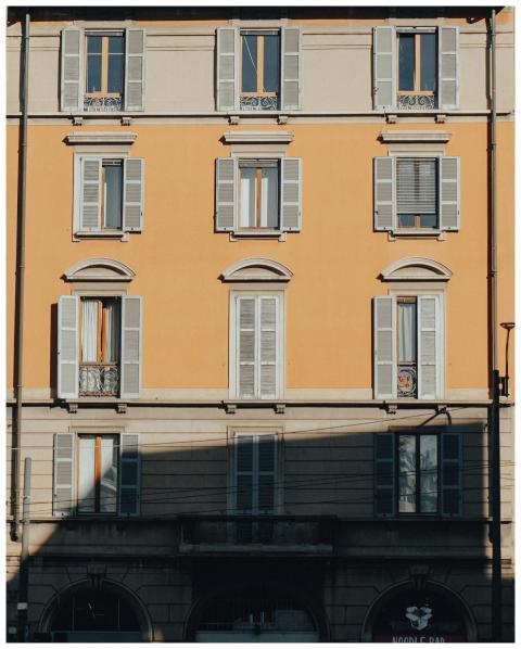Sunlit facade of a classic building in Milan, show