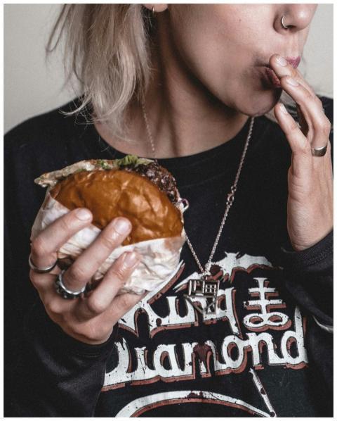 A woman savoring a delicious beef burger, featurin
