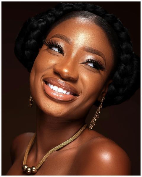 Portrait of a smiling woman with braided hair, ear