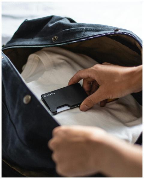 Close-up of a person placing a wallet into a trave