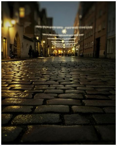 Illuminated cobblestone street during evening with