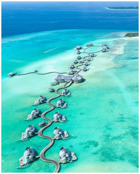 Aerial view of luxury overwater villas at Noonu At
