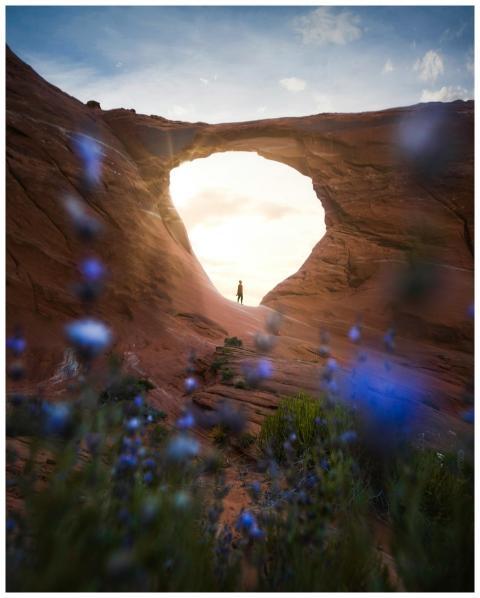 A lone figure stands silhouetted under a beautiful