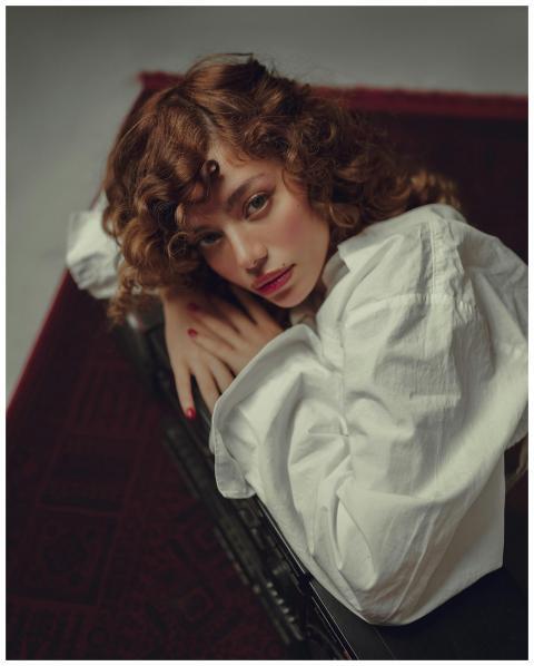 Artistic portrait of a woman lying on a carpet wit