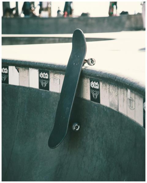Close-up of a skateboard leaning against a skatepa