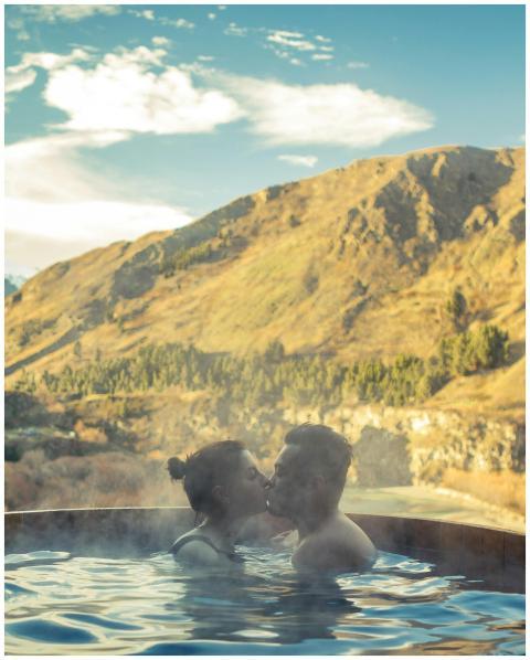 A couple shares a romantic moment in a hot pool wi