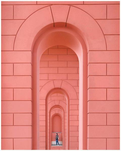 Person walking through a series of vibrant pink ar