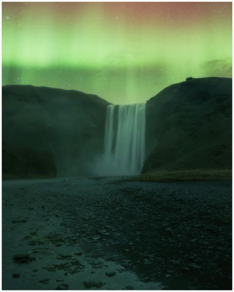 Skogafoss waterfall illuminated by the vibrant aur