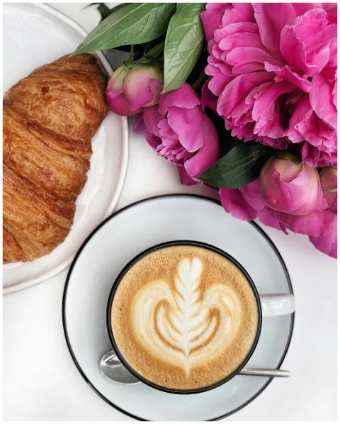 Flat lay of a cappuccino with froth art, croissant