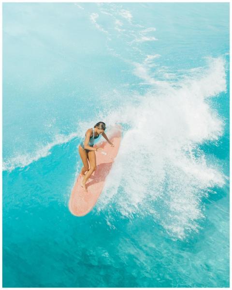 Aerial view of a female surfer skillfully riding w