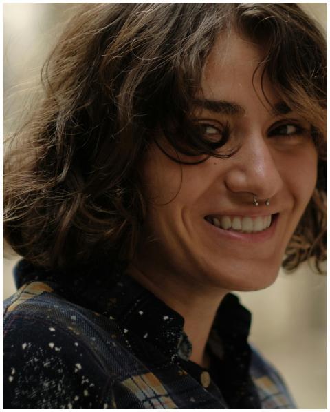 Close-up portrait of a smiling woman with curly ha