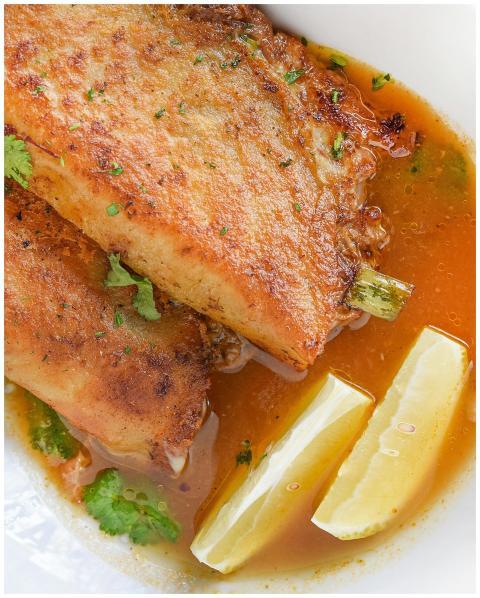 Close-up of fried fish paired with lemon wedges an