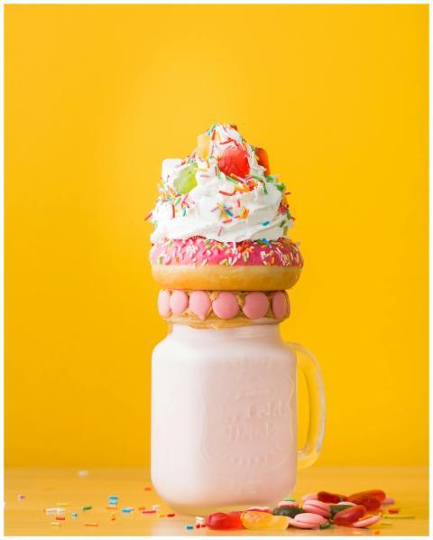 Vibrant milkshake adorned with a donut, whipped cr
