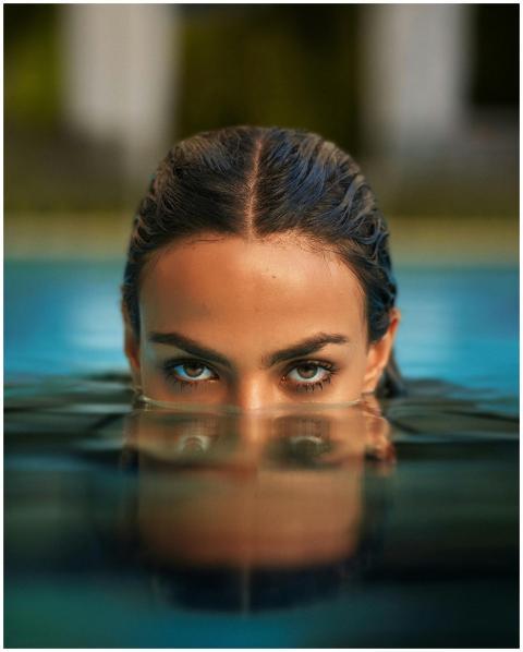 Close-up shot of a woman's eyes above water, conve