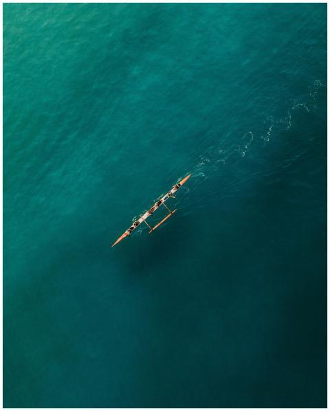 A top-down view of a canoe with people paddling on