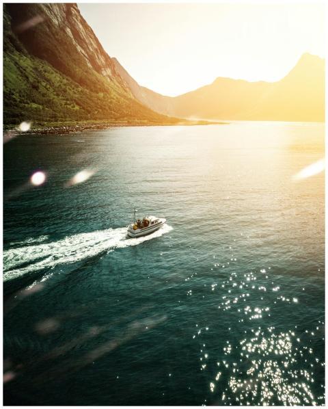 An aerial shot of a motorboat cruising on a mounta