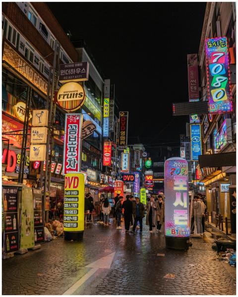 Bustling Seoul street scene with neon signs and pe