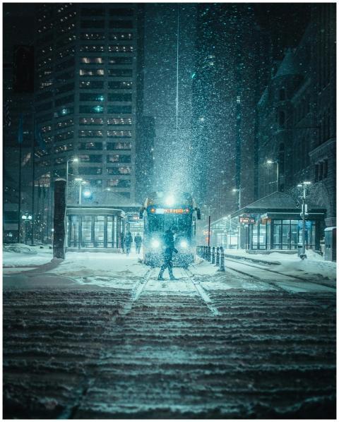 A snowy night scene with tram in downtown Minneapo