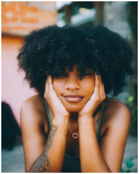Stylish woman with afro hairstyle and nose piercin
