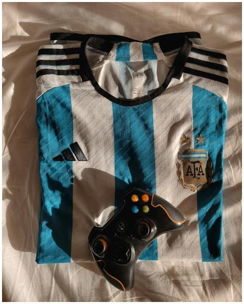 Argentina football jersey and gaming controller on