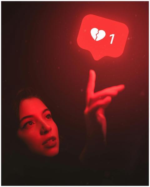 Red-hued image of a woman reaching towards a broke