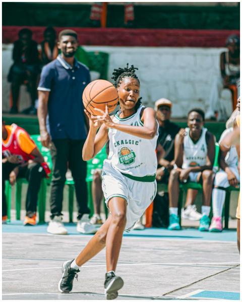 Energetic female basketball player dribbling durin