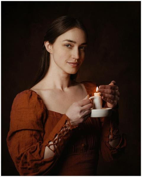 Portrait of a woman in medieval attire holding a c