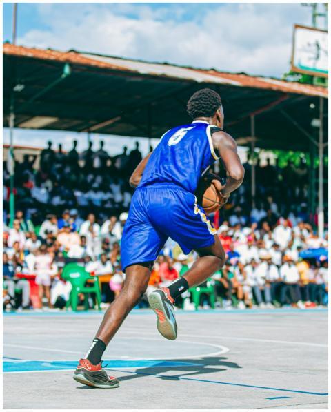 Basketball player dribbles on outdoor court with c