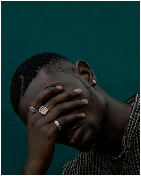 Close-up portrait of a man with hand covering face