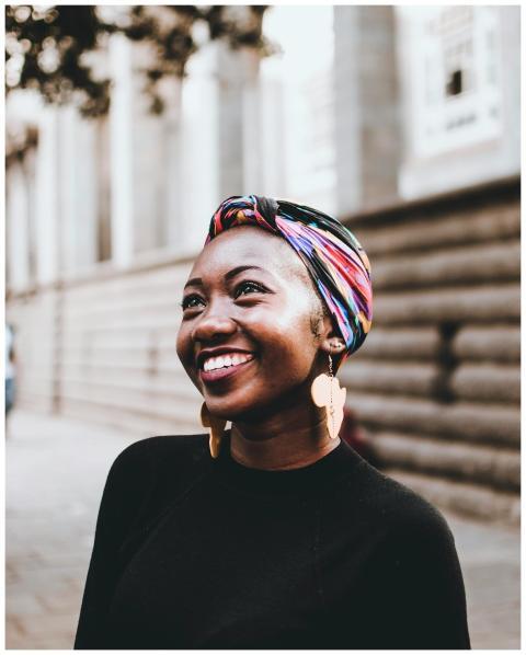 Smiling woman wearing vibrant headscarf and earrin