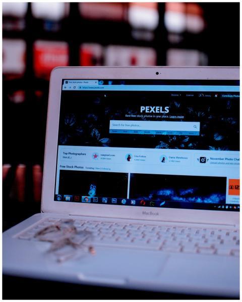 Laptop on a desk showing the Pexels homepage, high