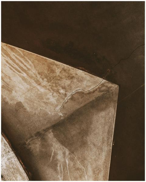 Abstract image of a cracked, stained concrete ceil