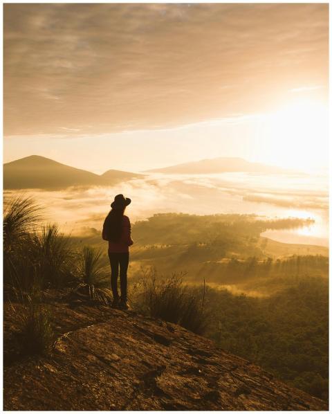 Silhouette of a person hiking and enjoying a spraw