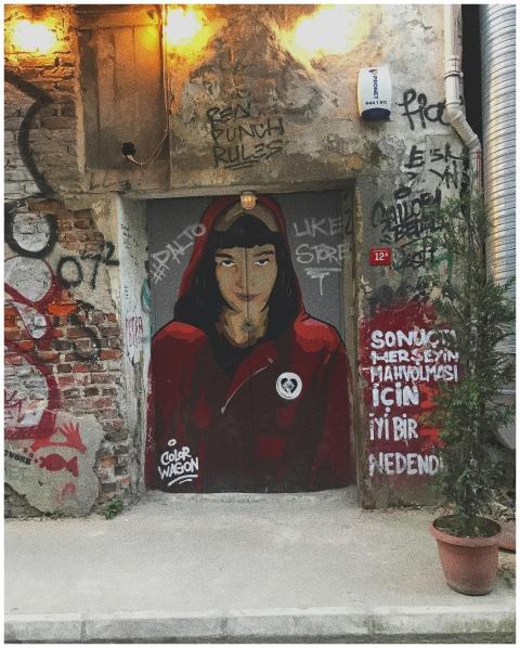 Vibrant street art of a woman in a red hood captur
