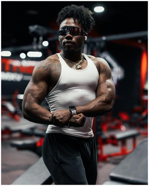 Strong man posing in gym, showcasing muscle defini